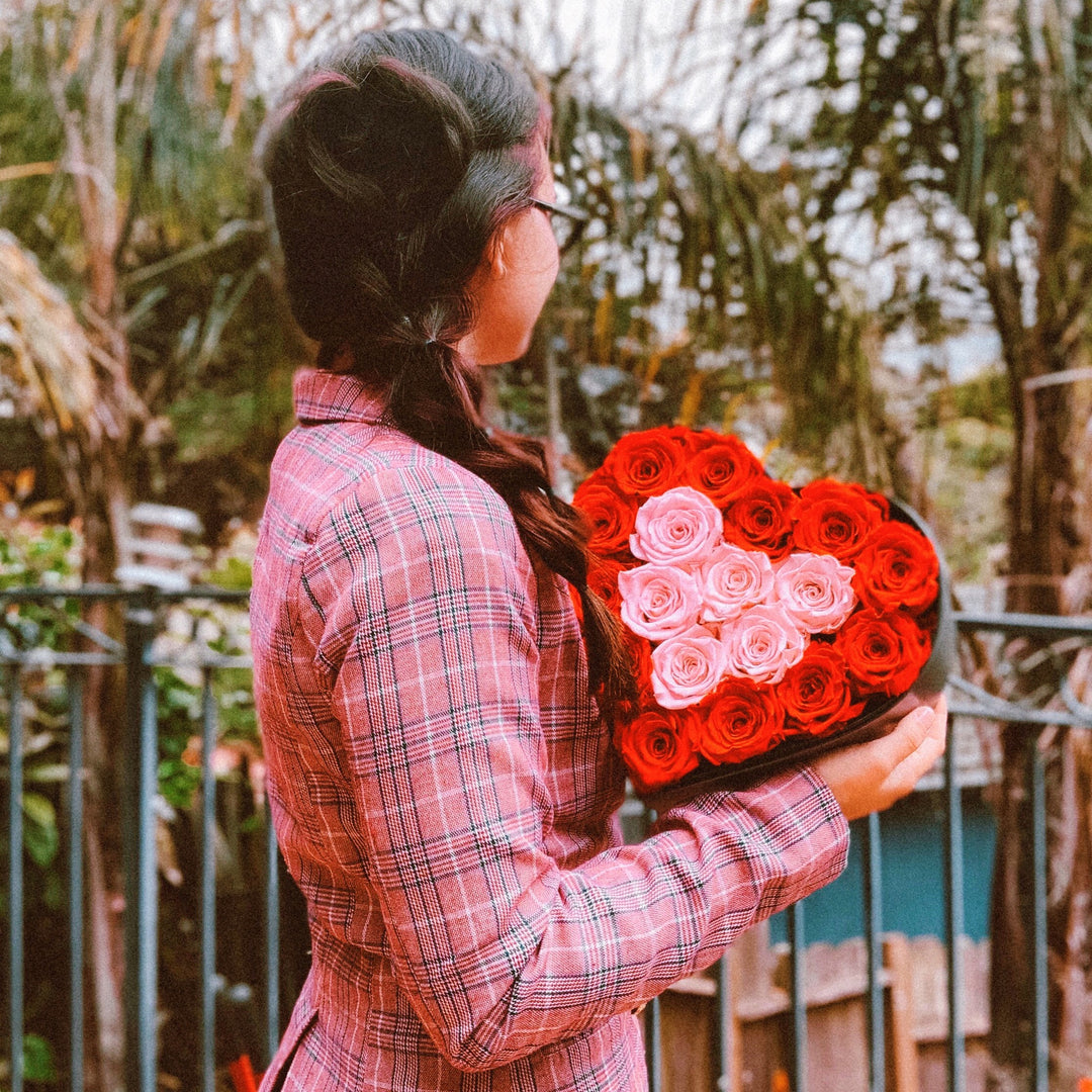 Woman holding a shadow box rose from The Only Roses